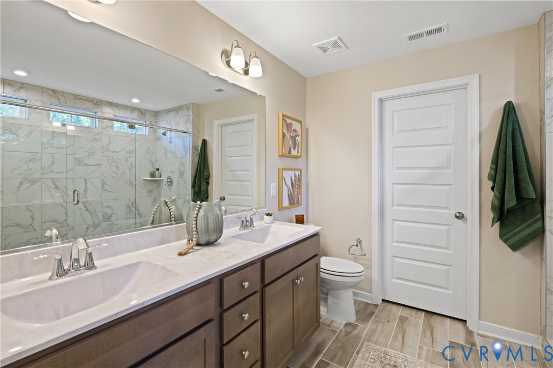 979 Charlemagne Road Midlothian, VA 23114 - Photo 28 of 50 a bathroom with a double vanity sink and mirror