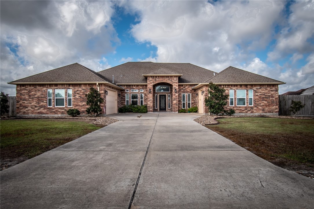 a front view of a house with a yard and trees
