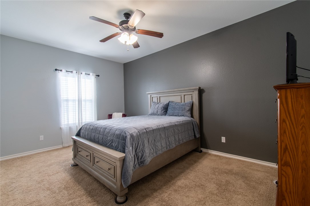 5309 Capernaum Court Corpus Christi, TX 78413 - Photo 11 of 40 a spacious bedroom with a bed and a chandelier