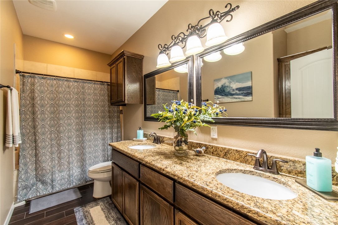 5309 Capernaum Court Corpus Christi, TX 78413 - Photo 12 of 40 a bathroom with a granite countertop sink toilet and shower