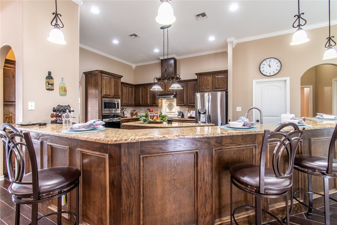 5309 Capernaum Court Corpus Christi, TX 78413 - Photo 20 of 40 a kitchen with a table chairs refrigerator and microwave