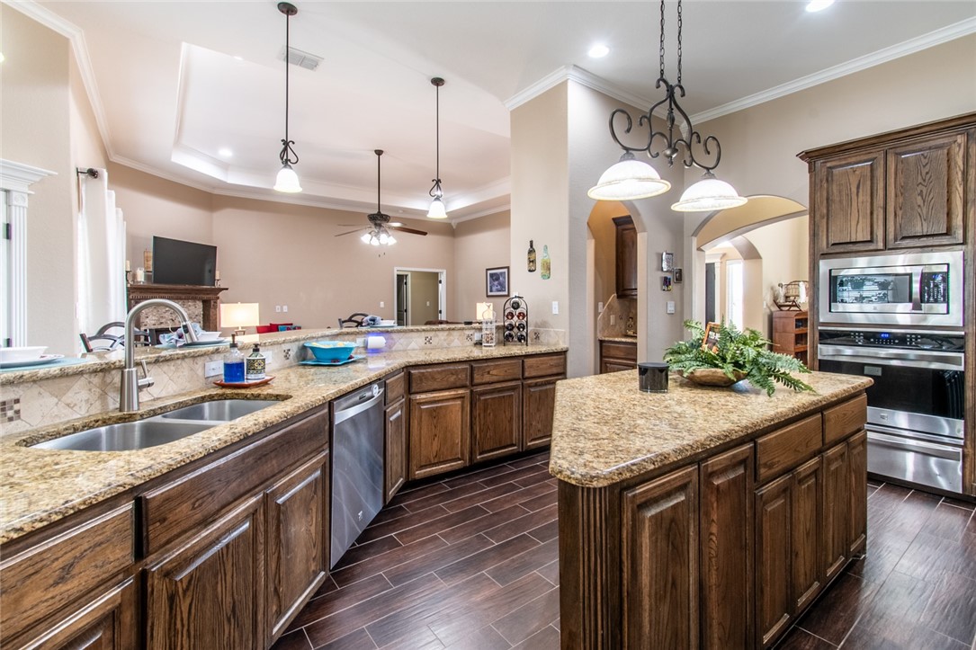 5309 Capernaum Court Corpus Christi, TX 78413 - Photo 24 of 40 a kitchen with stainless steel appliances granite countertop wooden floors stove sink and cabinets