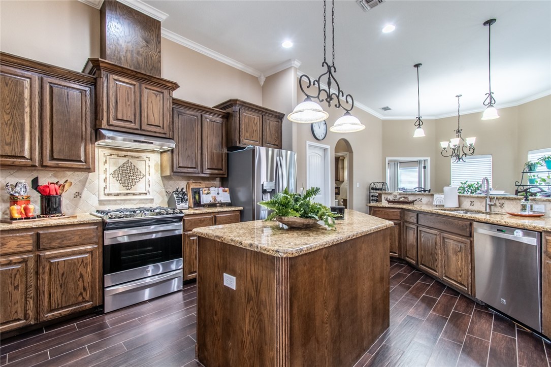 5309 Capernaum Court Corpus Christi, TX 78413 - Photo 30 of 40 a kitchen with stainless steel appliances granite countertop a sink a stove and a wooden floors