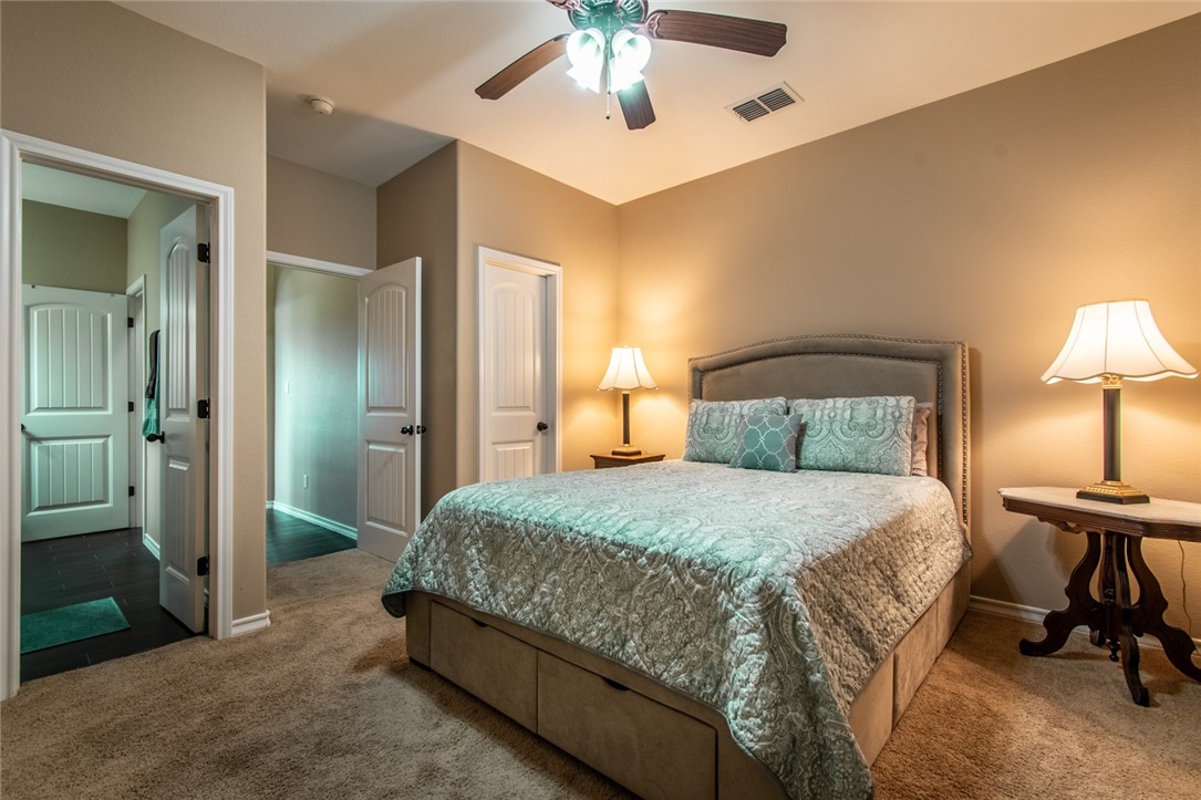 5309 Capernaum Court Corpus Christi, TX 78413 - Photo 9 of 40 a bedroom with a bed and a chandelier