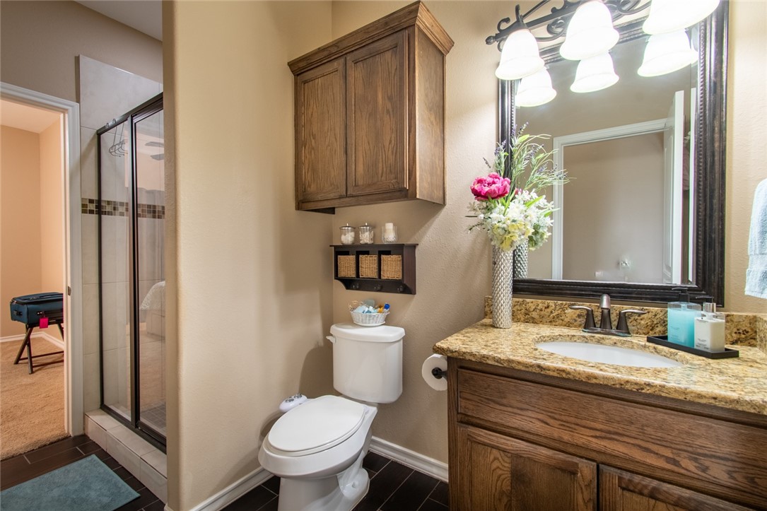 5309 Capernaum Court Corpus Christi, TX 78413 - Photo 10 of 40 a bathroom with a granite countertop sink vanity mirror and toilet
