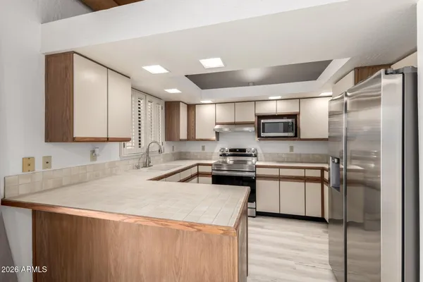 a kitchen with stainless steel appliances a refrigerator sink and microwave
