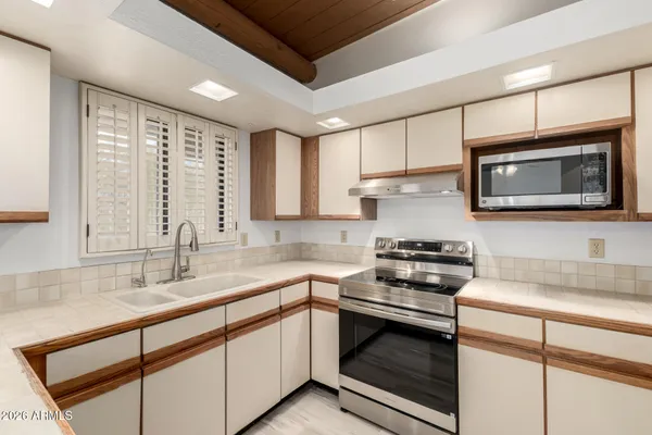 a kitchen with stainless steel appliances a stove sink microwave and cabinets