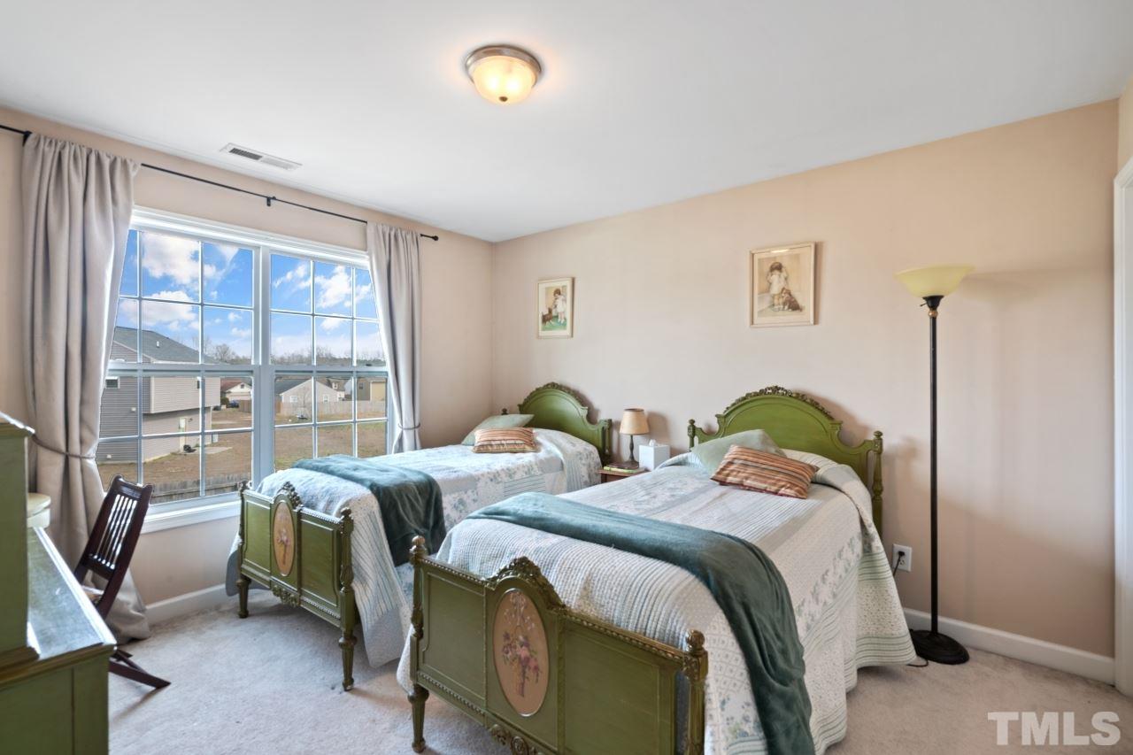 2307 King Malcolm Lane Zebulon, NC 27597 - Photo 18 of 30 a bedroom with two beds and glass door