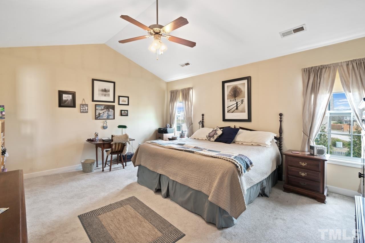 2307 King Malcolm Lane Zebulon, NC 27597 - Photo 21 of 30 a spacious bedroom with a bed a table and chair