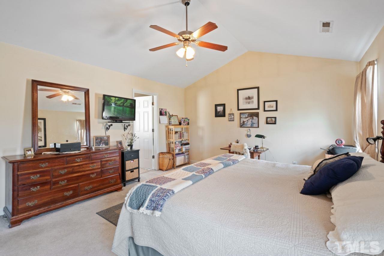 2307 King Malcolm Lane Zebulon, NC 27597 - Photo 22 of 30 a bedroom with a bed and a dresser with mirror