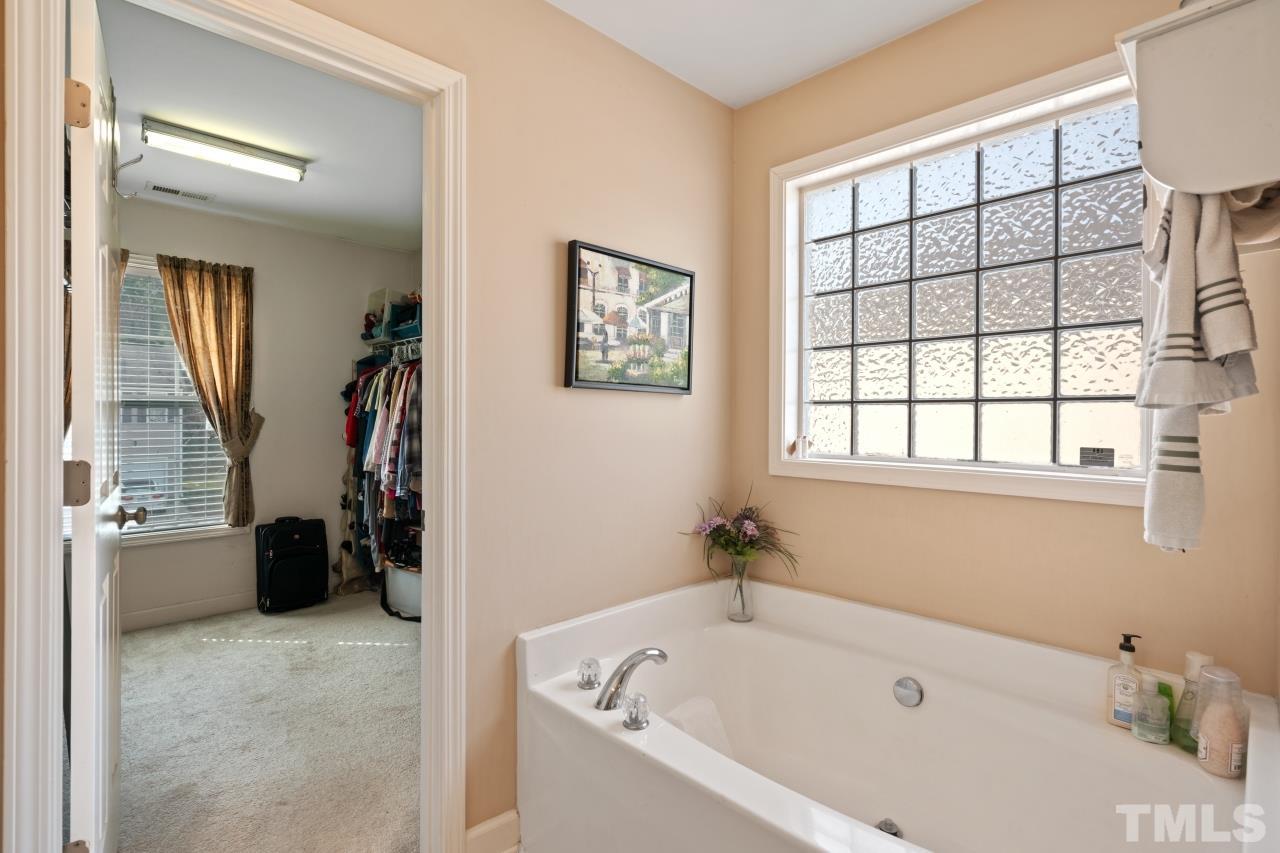2307 King Malcolm Lane Zebulon, NC 27597 - Photo 25 of 30 a white bath tub sitting in a en suite bathroom next to a window