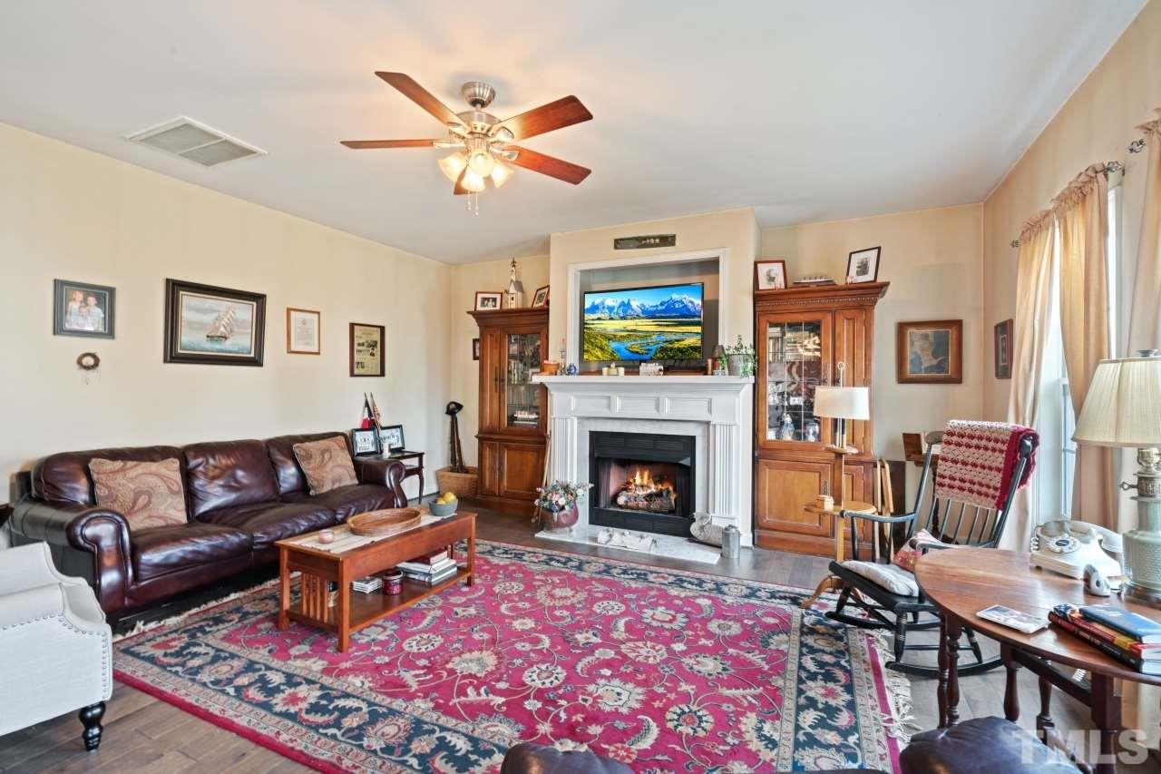 2307 King Malcolm Lane Zebulon, NC 27597 - Photo 8 of 30 a living room with furniture a flat screen tv and a fireplace