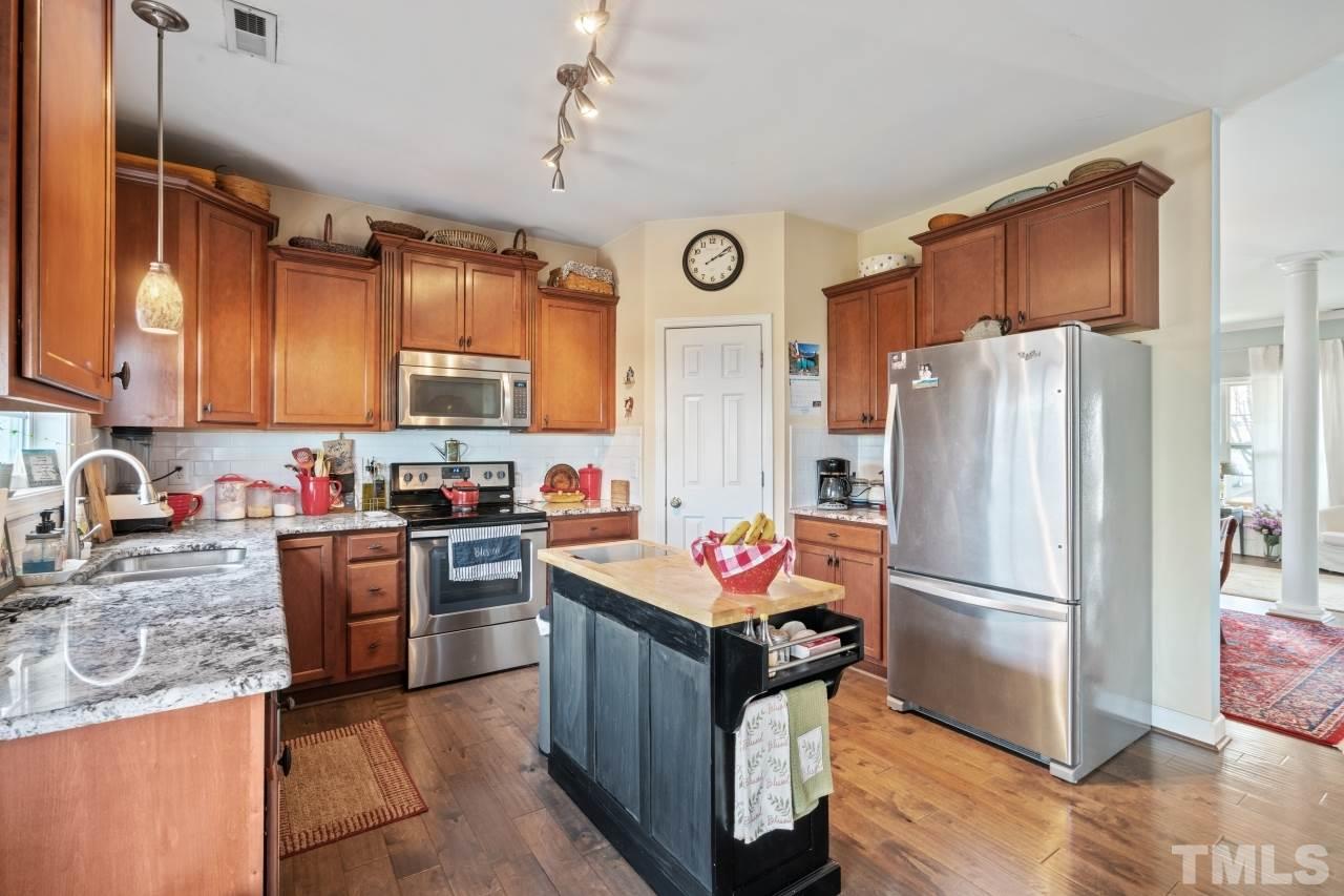 2307 King Malcolm Lane Zebulon, NC 27597 - Photo 9 of 30 a kitchen with stainless steel appliances granite countertop a refrigerator a stove top oven a sink and dishwasher