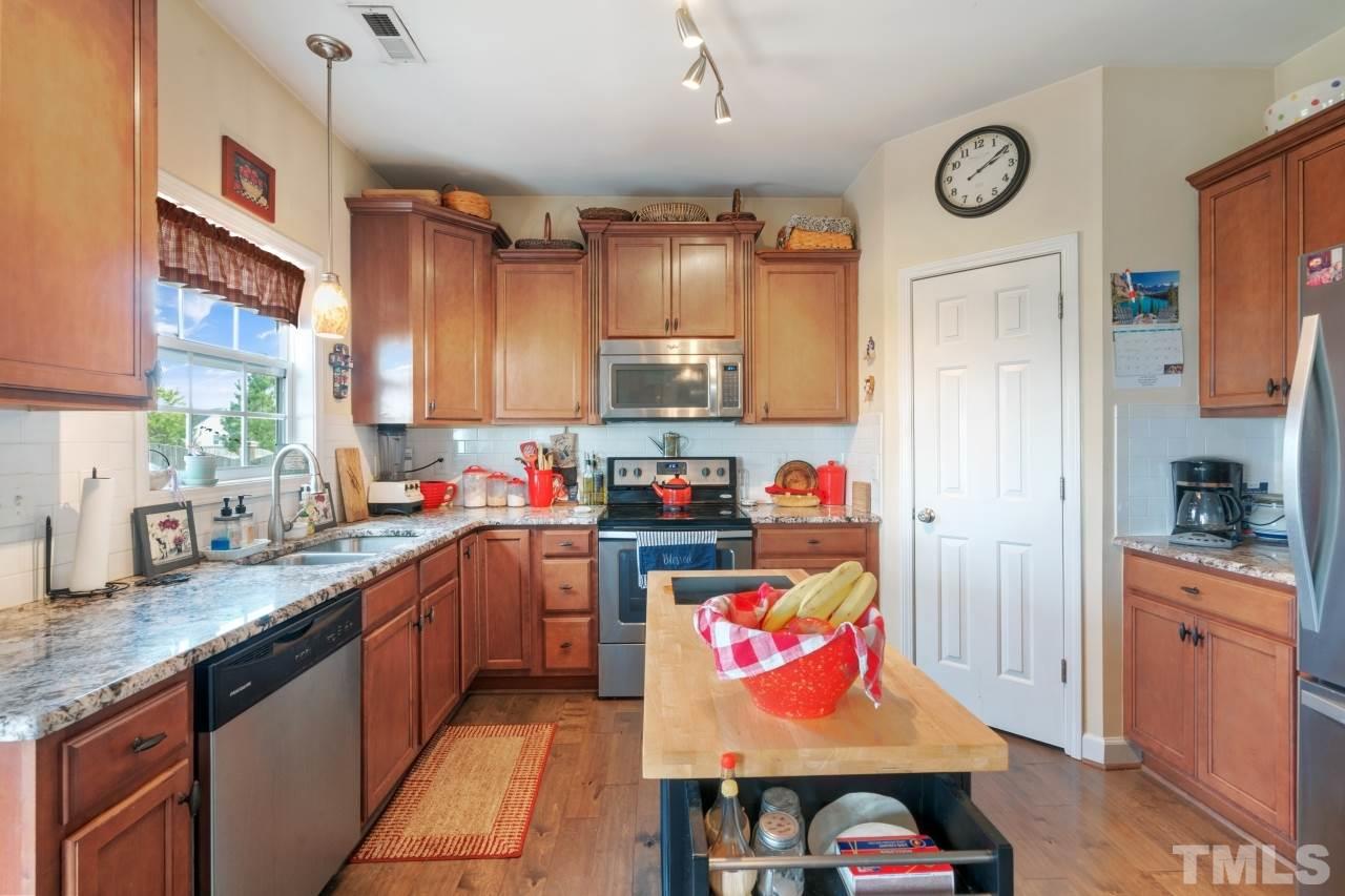 2307 King Malcolm Lane Zebulon, NC 27597 - Photo 10 of 30 a kitchen with stainless steel appliances granite countertop a stove and refrigerator