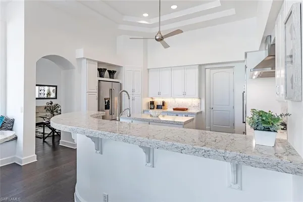 a kitchen with kitchen island a counter top space a sink stainless steel appliances and cabinets