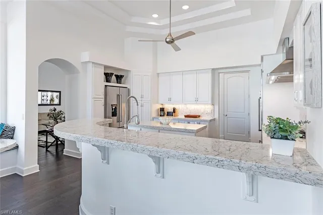 a kitchen with kitchen island a counter top space a sink stainless steel appliances and cabinets