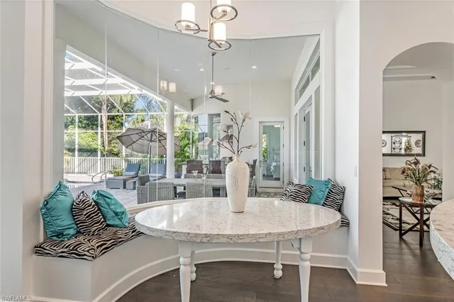 a dining room with furniture a chandelier and wooden floor