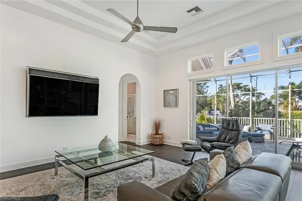 a living room with furniture a flat screen tv and a window