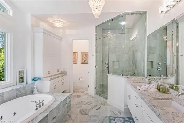 a bathroom with a granite countertop tub sink a shower and a mirror
