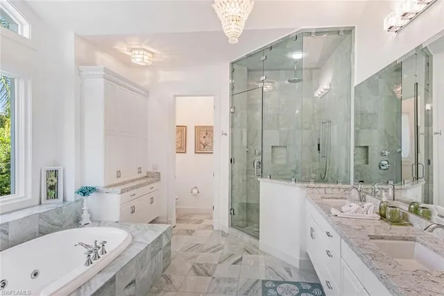 a bathroom with a granite countertop tub sink a shower and a mirror