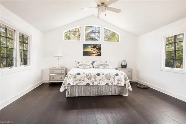 a bedroom with a bed wooden floor and window