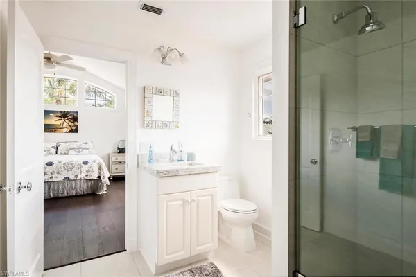 a en suite bathroom with a granite countertop sink and a mirror