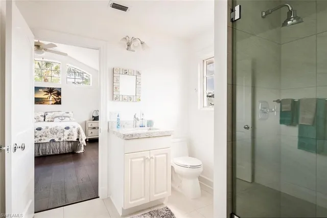 a en suite bathroom with a granite countertop sink and a mirror