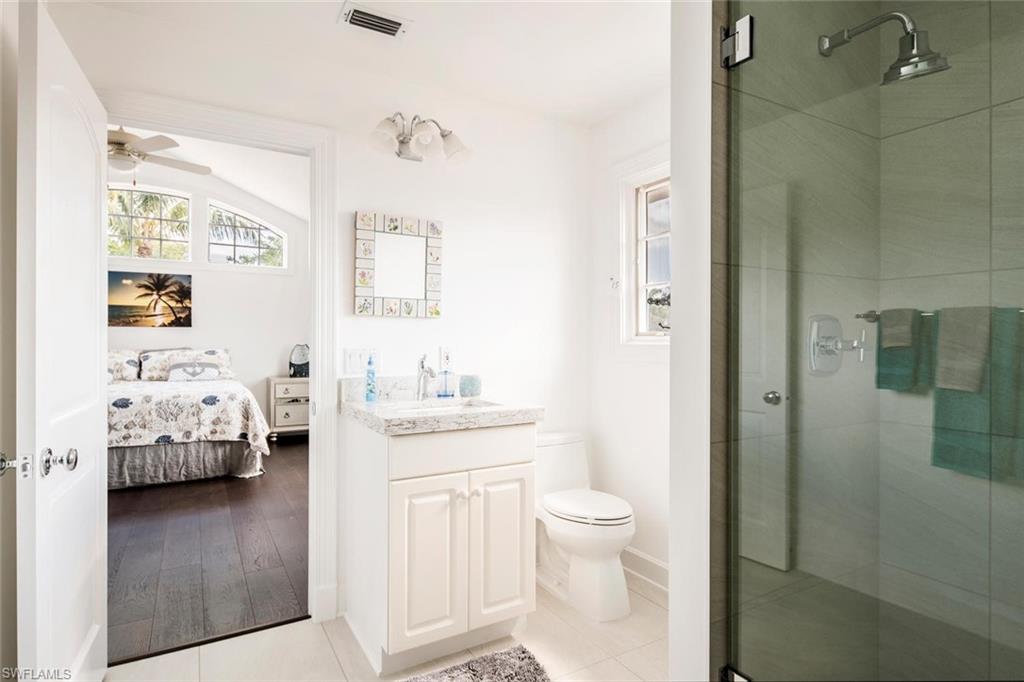 2540 Half Moon Walk Naples, FL 34102 - Photo 36 of 44 a en suite bathroom with a granite countertop sink and a mirror