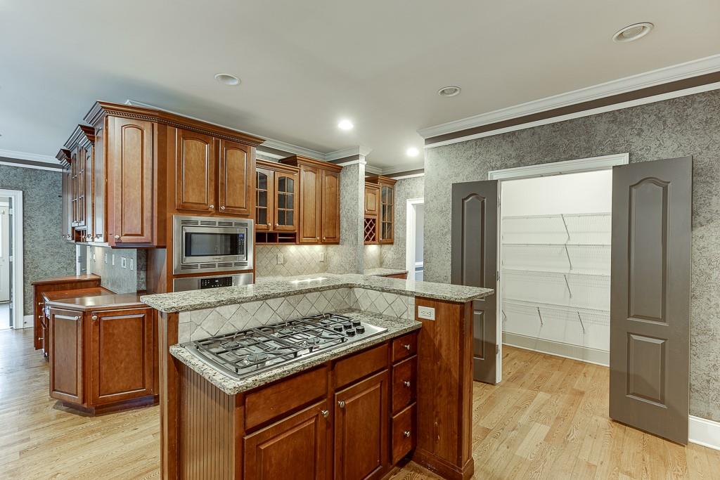 940 Chateau Forest Road Hoschton, GA 30548 - Photo 26 of 87 a kitchen with kitchen island granite countertop a sink stove and refrigerator