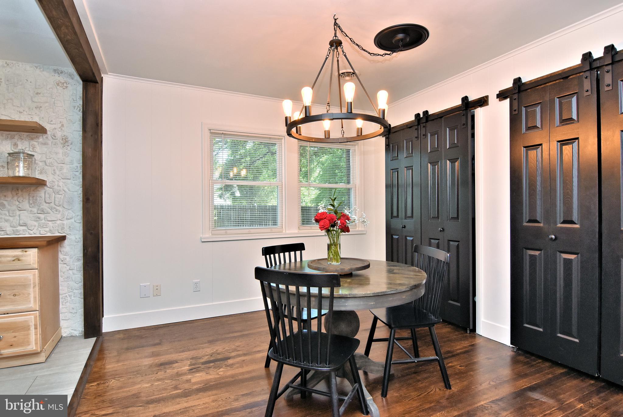 9012 Concord Road Seaford, DE 19973 - Photo 5 of 24 a dining room with wooden floor a chandelier a wooden table and chairs