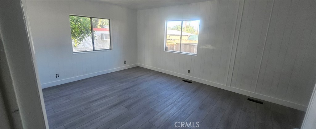 995 Pomona Road, Unit 33 Corona, CA 92882 - Photo 3 of 8 an empty room with wooden floor and windows