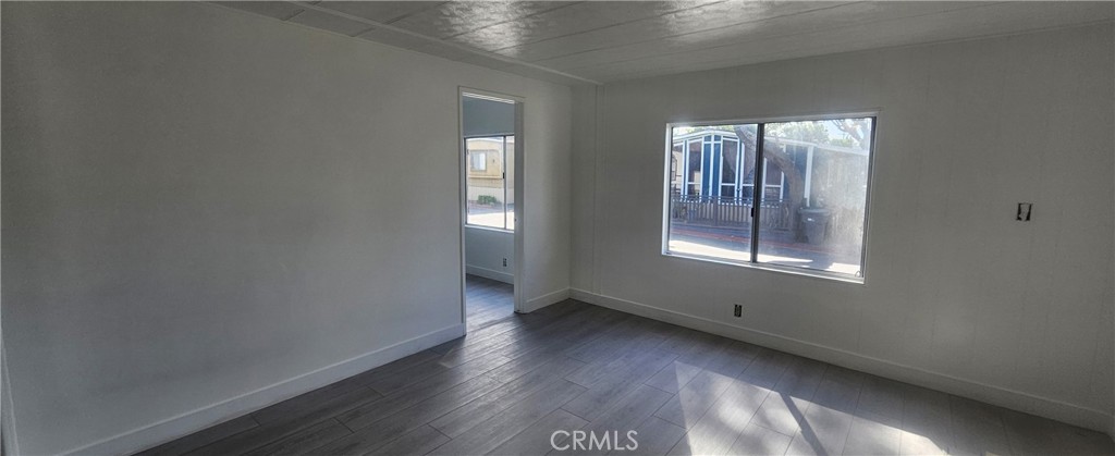 995 Pomona Road, Unit 33 Corona, CA 92882 - Photo 4 of 8 an empty room with wooden floor and windows