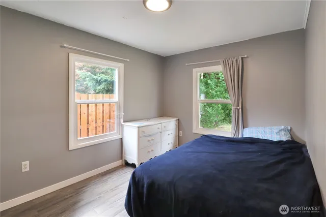 a view of a bedroom with wooden floor and a window
