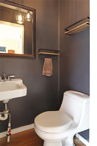 a bathroom with a toilet sink and mirror