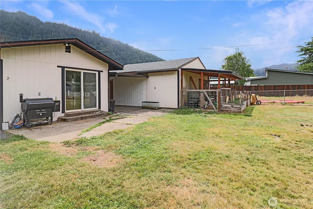 a view of a house with a yard and sitting area