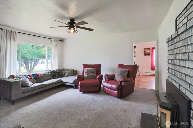 a living room with furniture fireplace and a large window
