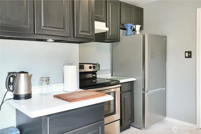 a kitchen with stainless steel appliances granite countertop a sink and a refrigerator