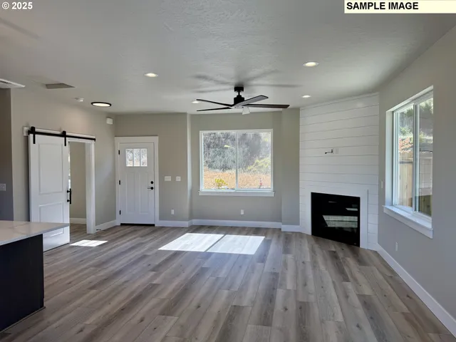 an empty room with windows and a fireplace