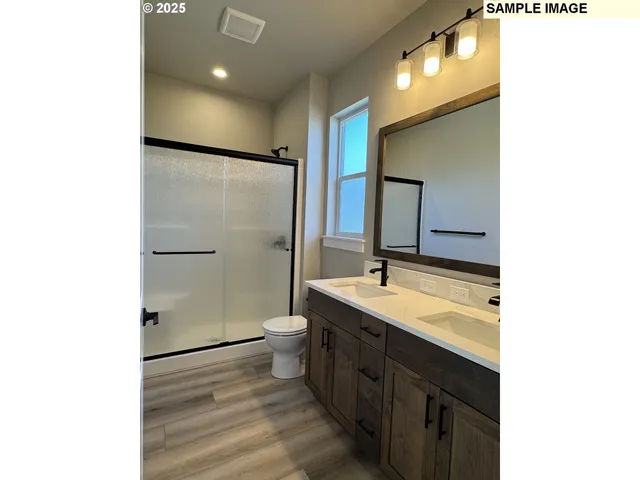 a bathroom with a sink a toilet a mirror and shower