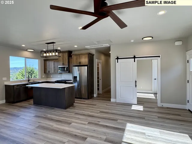 a large kitchen with stainless steel appliances granite countertop a stove and a refrigerator