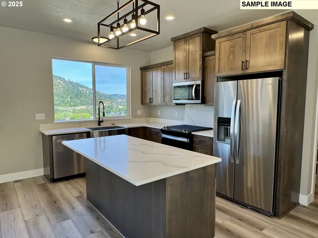 a kitchen with stainless steel appliances a sink stove and refrigerator