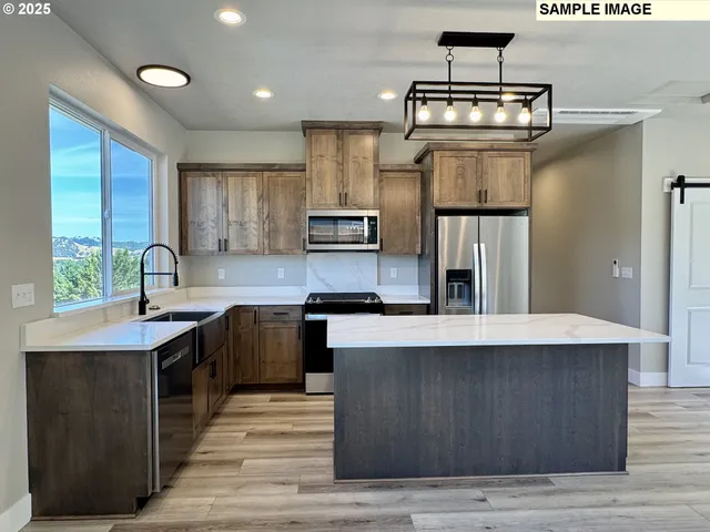 a kitchen with stainless steel appliances granite countertop a sink stove and refrigerator