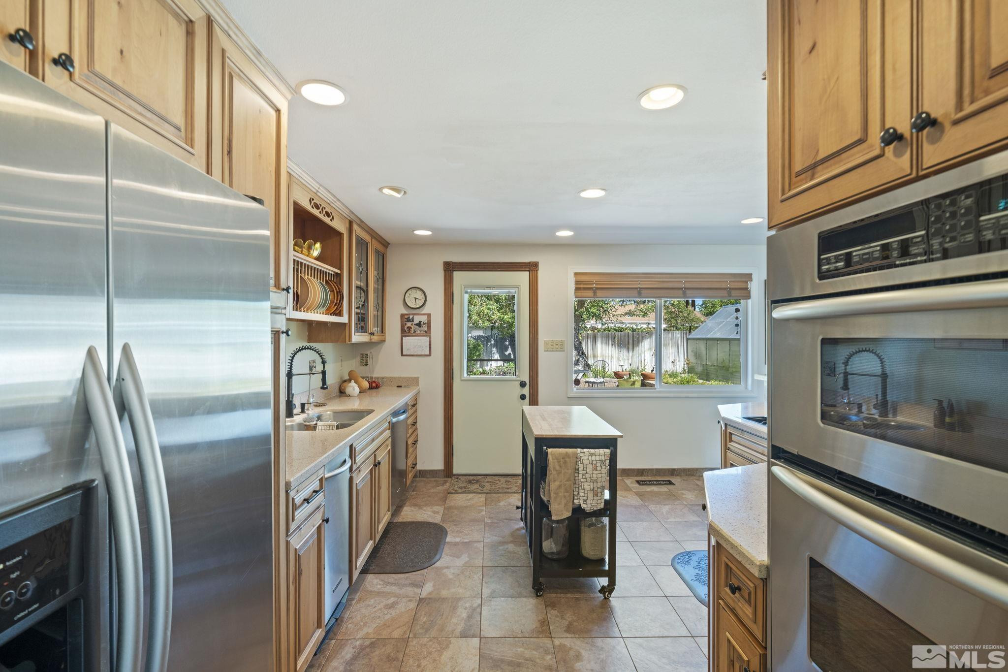 1000 Sumac Street Reno, NV 89509 - Photo 16 of 40 a kitchen with stainless steel appliances granite countertop a refrigerator a stove and a sink with large window