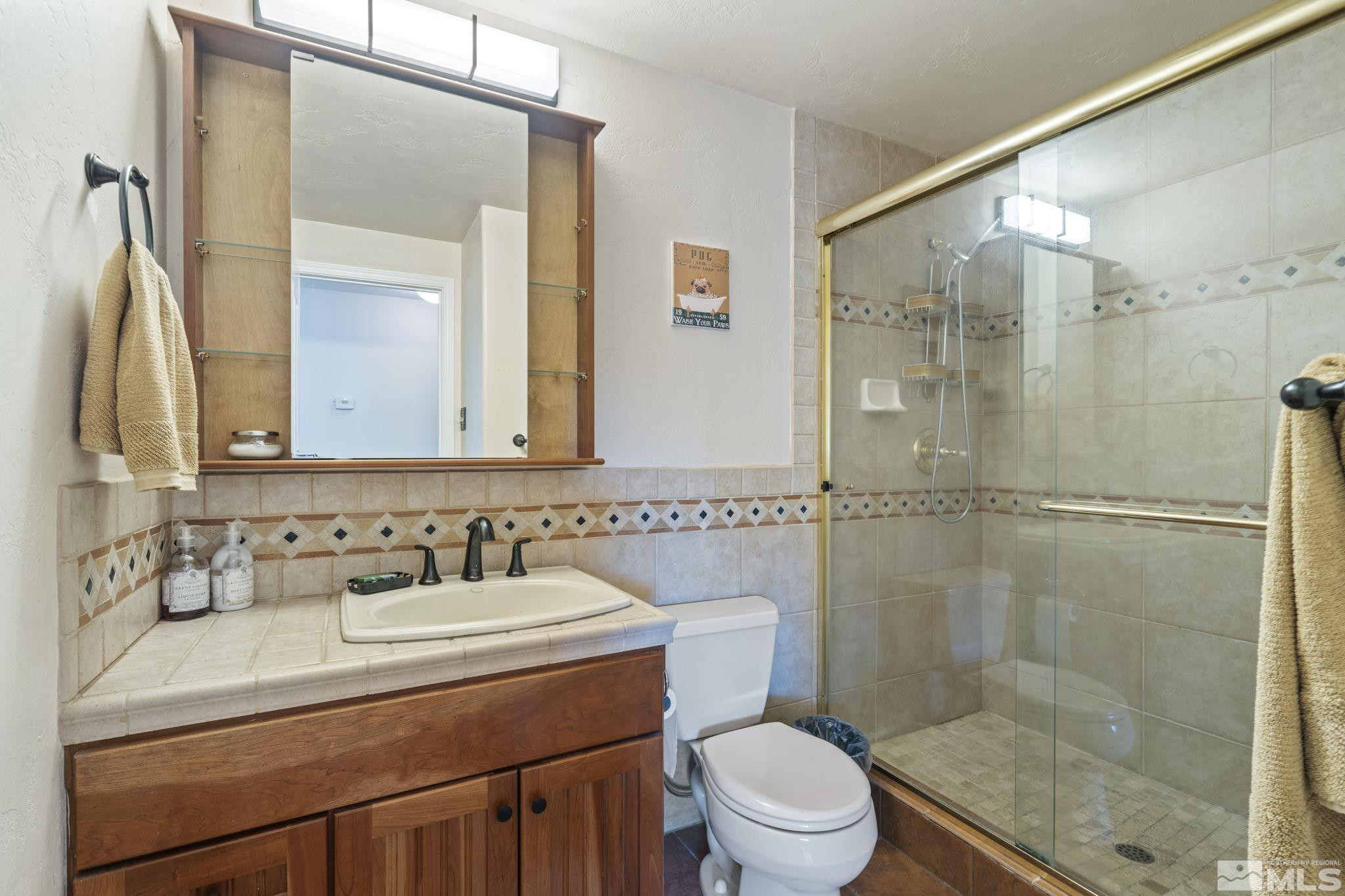 1000 Sumac Street Reno, NV 89509 - Photo 26 of 40 a bathroom with a sink a mirror a toilet and shower
