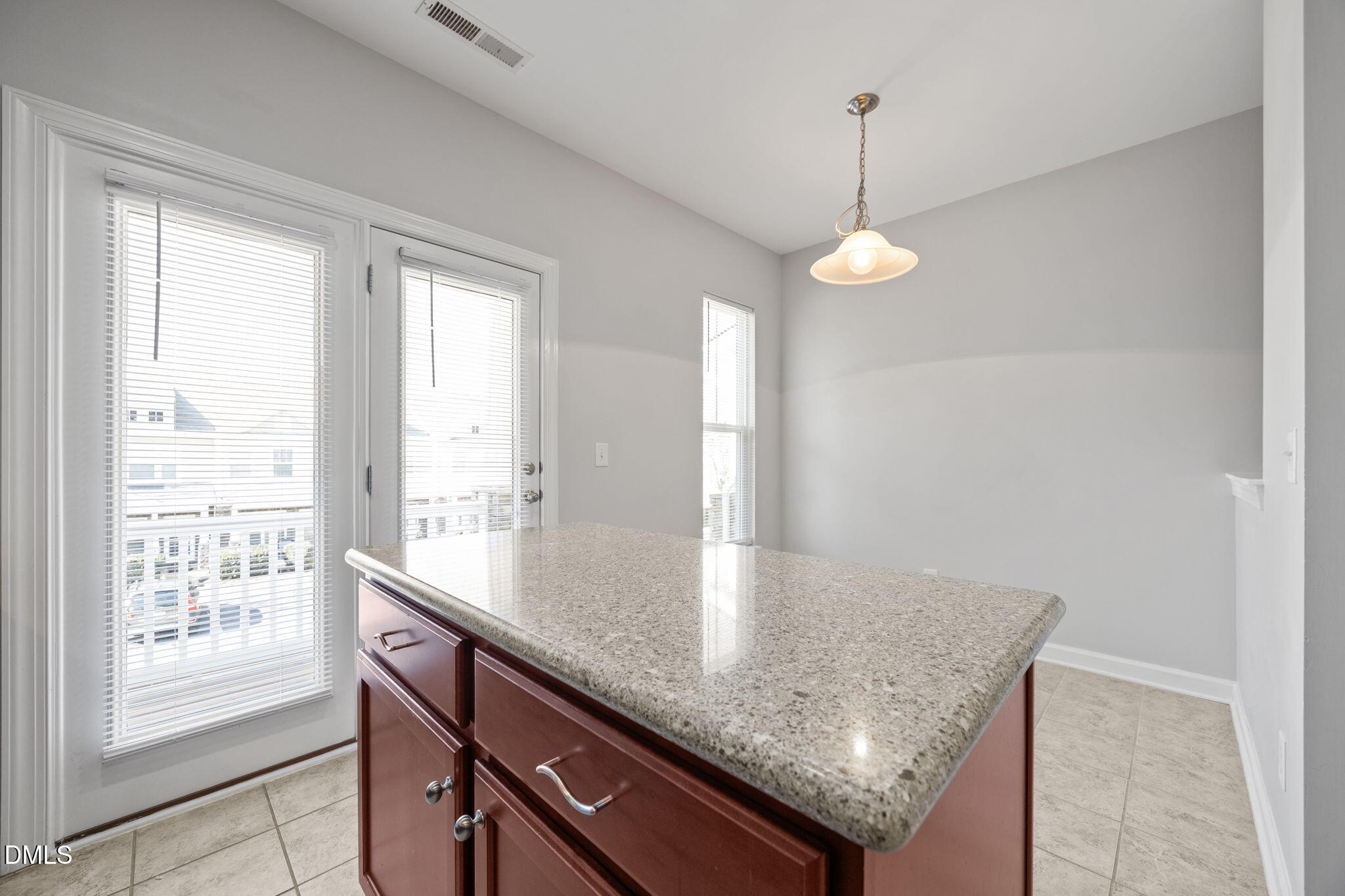 8006 Goldenrain Way Raleigh, NC 27612 - Photo 11 of 40 a kitchen with granite countertop kitchen island with a large window cabinets and stainless steel appliances