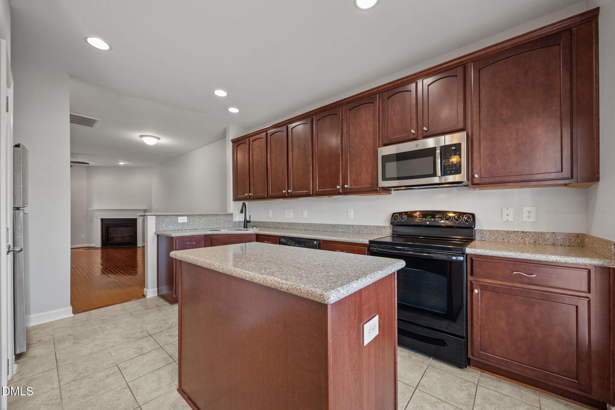 8006 Goldenrain Way Raleigh, NC 27612 - Photo 14 of 40 a kitchen with kitchen island granite countertop stainless steel appliances stove microwave and sink