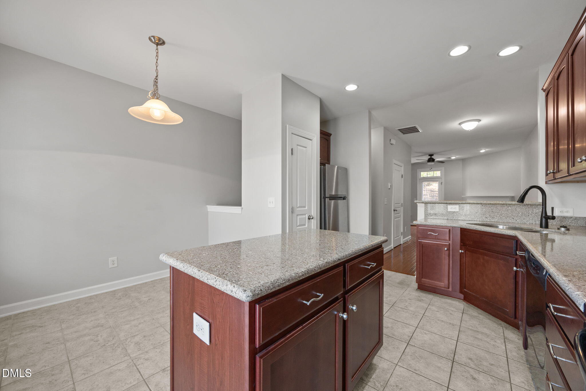 8006 Goldenrain Way Raleigh, NC 27612 - Photo 16 of 40 a kitchen with kitchen island granite countertop stainless steel appliances sink cabinets and stove