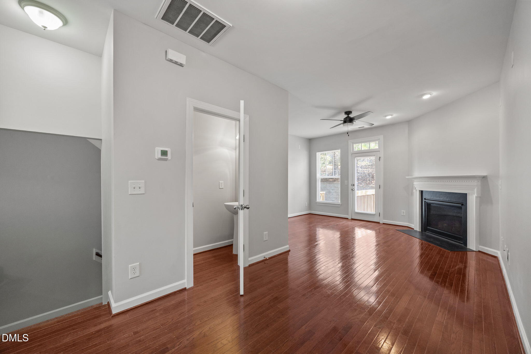 8006 Goldenrain Way Raleigh, NC 27612 - Photo 17 of 40 an empty room with wooden floor fireplace and windows
