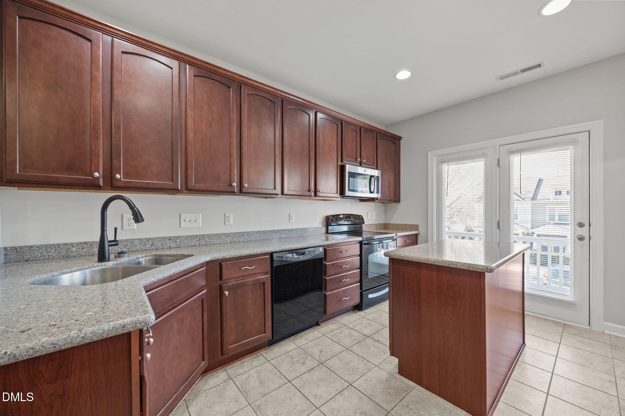 8006 Goldenrain Way Raleigh, NC 27612 - Photo 9 of 40 a kitchen with stainless steel appliances granite countertop a sink counter space cabinets and a large window