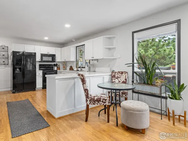 a living room with stainless steel appliances furniture a dining table and chairs